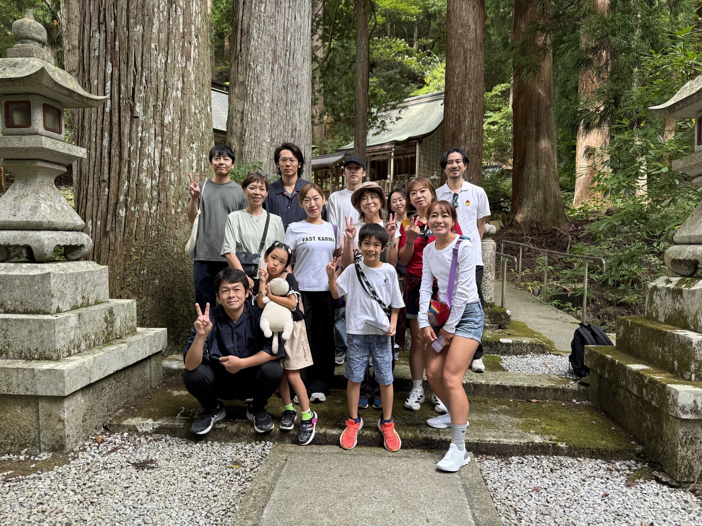 石段の下で笑顔で写真に収まる参加者たち